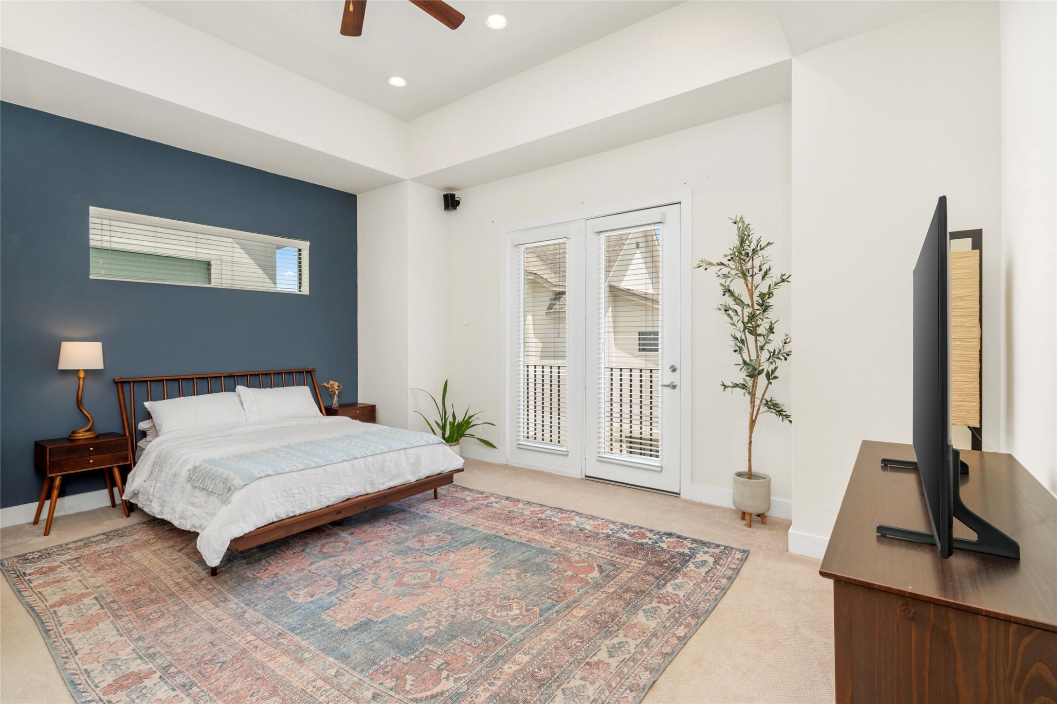 2609 Riverside Drive, Unit E Houston, TX 77004 - Photo 11 of 25 The spacious primary suite is finished with a deep blue accent wall and access to a private balcony.