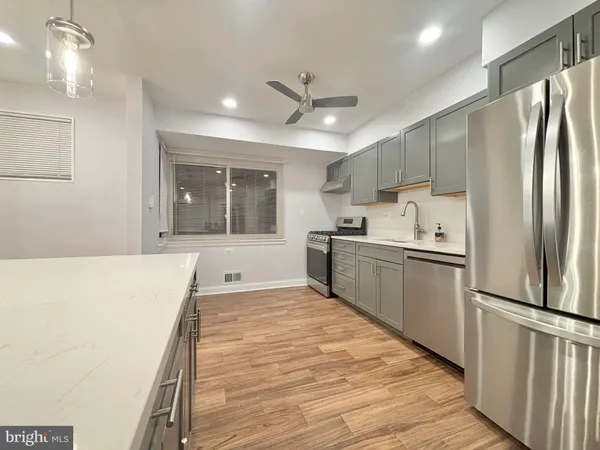 a large kitchen with stainless steel appliances a refrigerator and a stove top oven