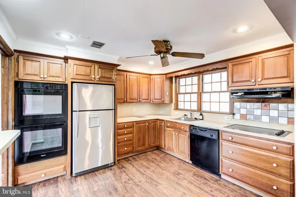 a kitchen with stainless steel appliances granite countertop a refrigerator a stove and a sink