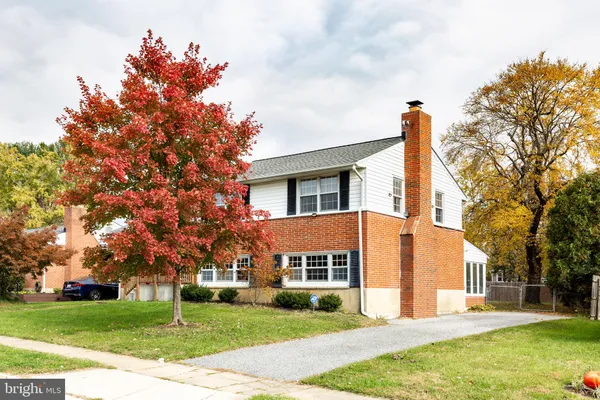 a front view of a house with a garden and tree
