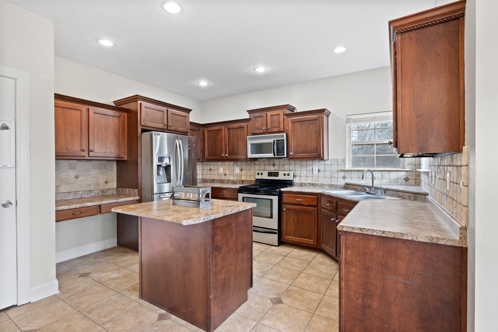 8169 Miller Road Atoka, TN 38004 - Photo 20 of 40 a kitchen with stainless steel appliances granite countertop a sink stove and refrigerator