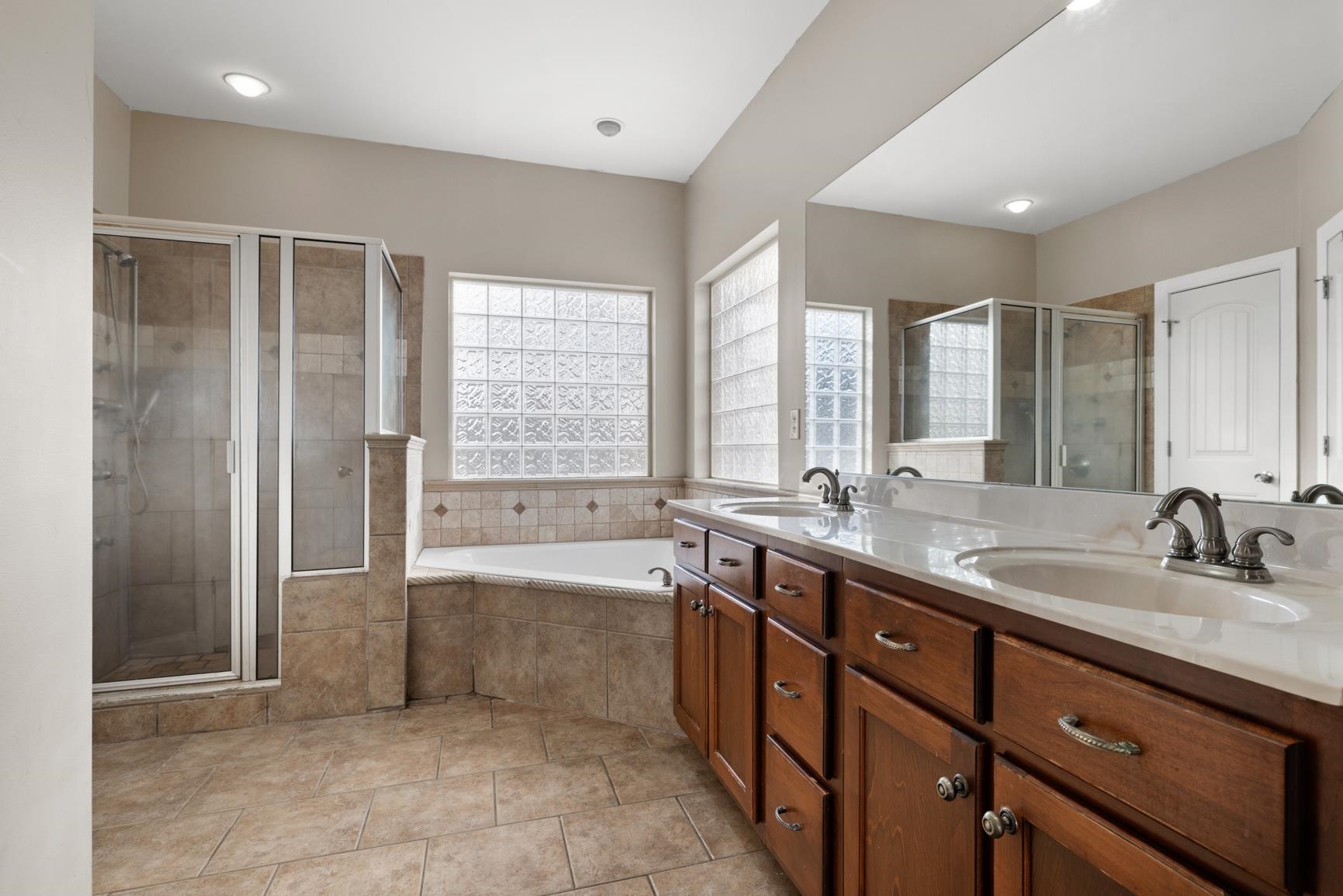 8169 Miller Road Atoka, TN 38004 - Photo 27 of 40 a large bathroom with a double vanity sink a large mirror and a bathtub
