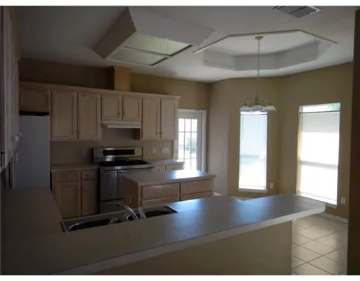 a kitchen with a sink stainless steel appliances a window and cabinets