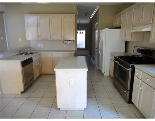 a kitchen with a stove a refrigerator and a sink