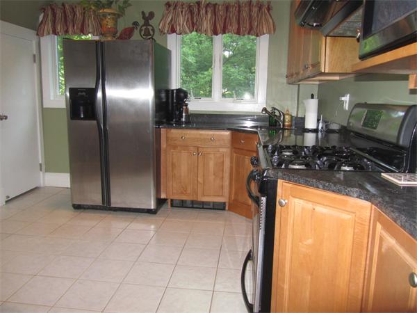84 Seaver Street Wellesley, MA 02481 - Photo 4 of 13 a kitchen with stainless steel appliances granite countertop a refrigerator a stove and a sink