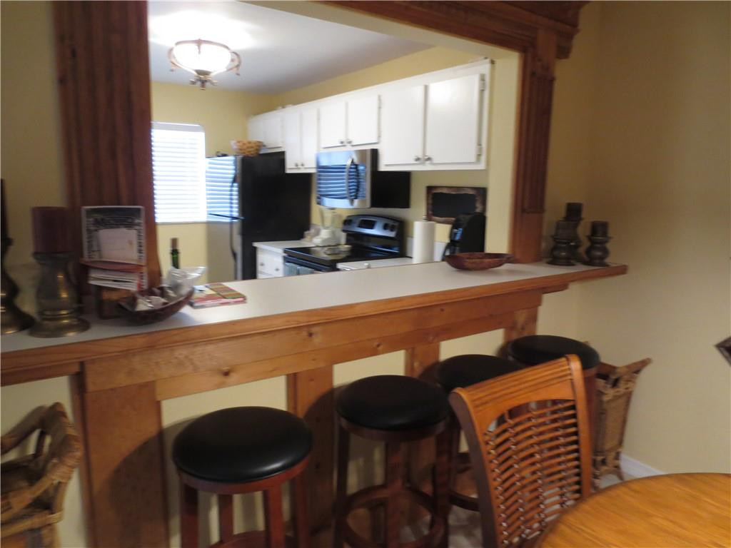 8822 West McNab Road, Unit 205 Tamarac, FL 33321 - Photo 11 of 20 a kitchen with a table chairs and a refrigerator
