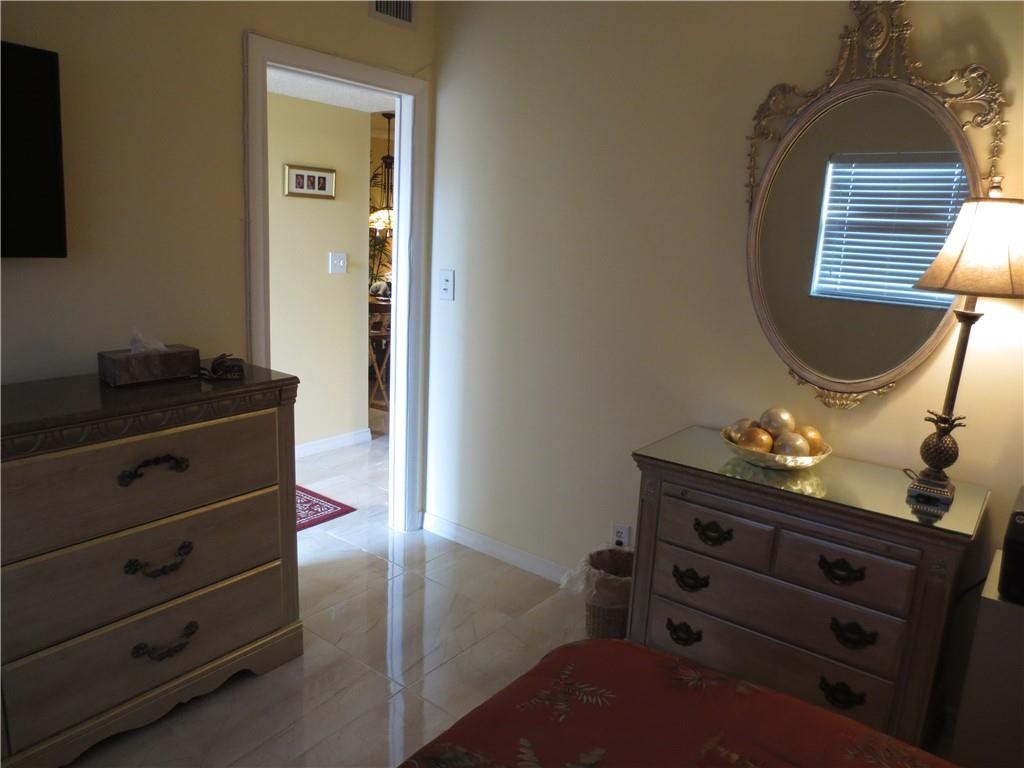 8822 West McNab Road, Unit 205 Tamarac, FL 33321 - Photo 13 of 20 a bed room with a bed and a dresser