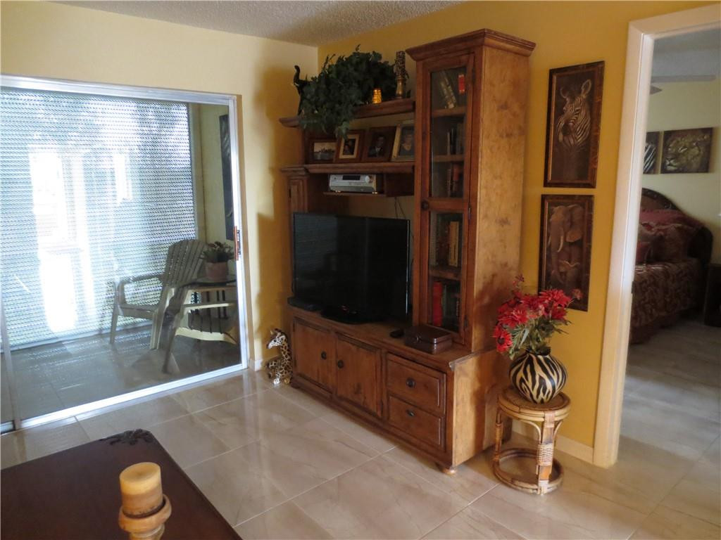 8822 West McNab Road, Unit 205 Tamarac, FL 33321 - Photo 19 of 20 a living room with furniture and a flat screen tv