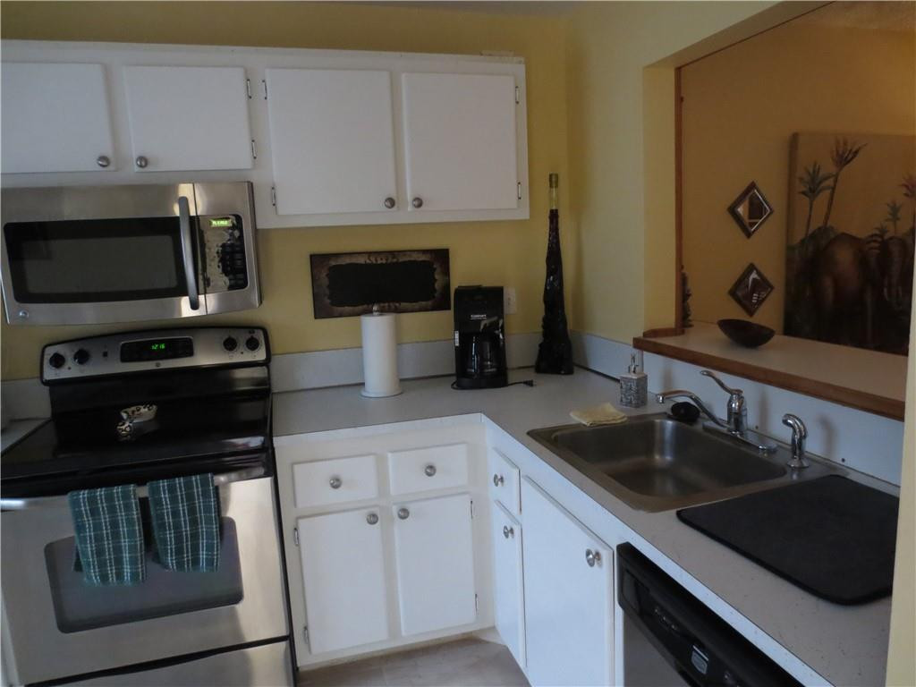 8822 West McNab Road, Unit 205 Tamarac, FL 33321 - Photo 2 of 20 a kitchen with granite countertop a sink a stove and cabinets