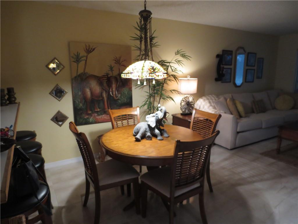 8822 West McNab Road, Unit 205 Tamarac, FL 33321 - Photo 5 of 20 a dining room with furniture and chandelier