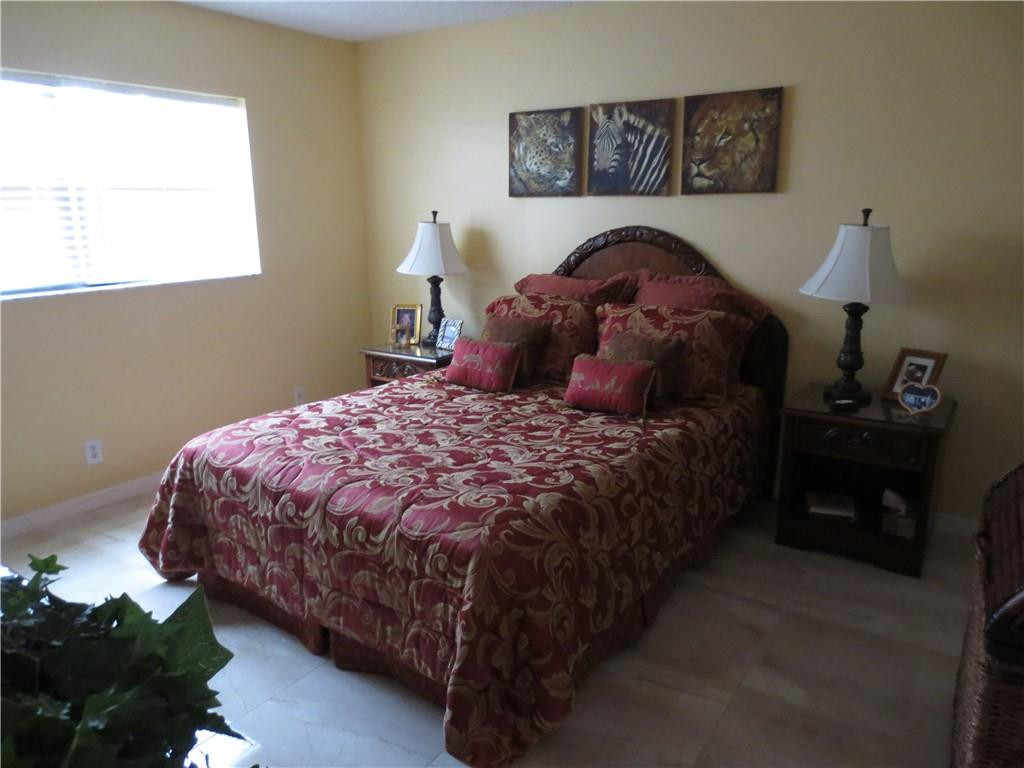 8822 West McNab Road, Unit 205 Tamarac, FL 33321 - Photo 7 of 20 a bedroom with a bed and a lamp on dresser