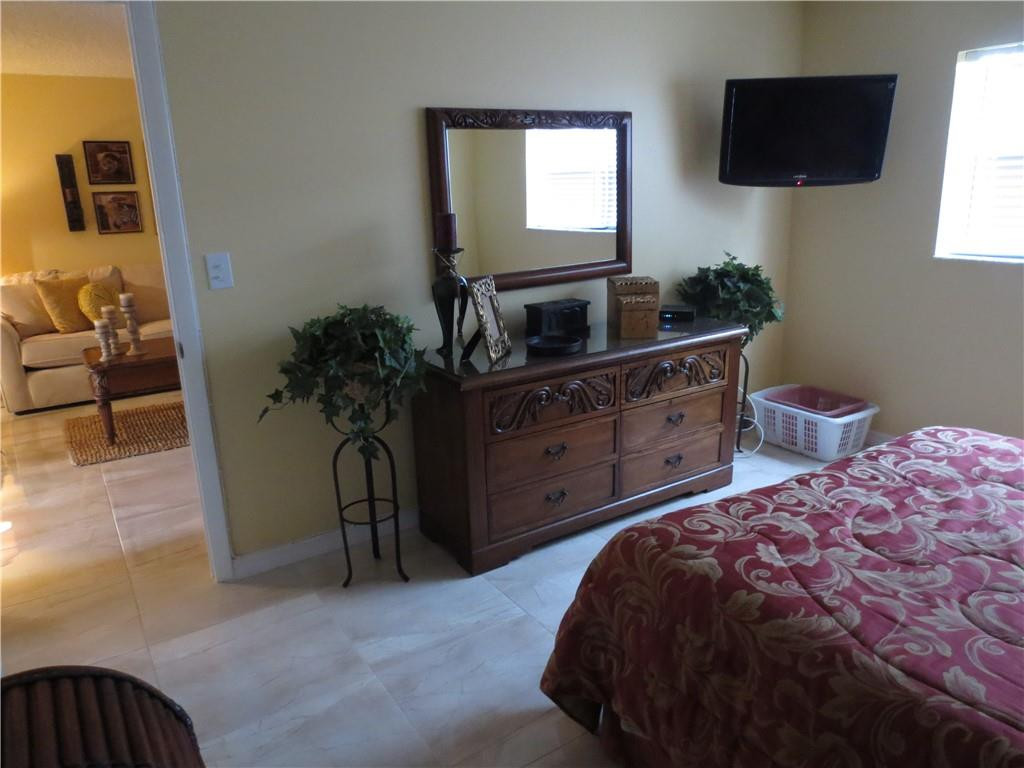 8822 West McNab Road, Unit 205 Tamarac, FL 33321 - Photo 8 of 20 a bedroom with a bed and a potted plant