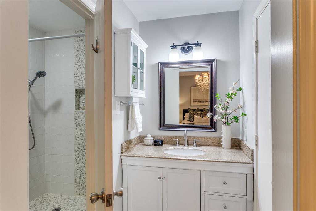 1295 Roaring Springs Road Fort Worth, TX 76114 - Photo 9 of 17 a bathroom with a granite countertop sink a mirror and a shower