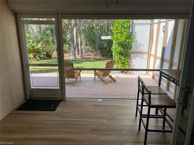 a view of a living room with a floor to ceiling window and wooden floor
