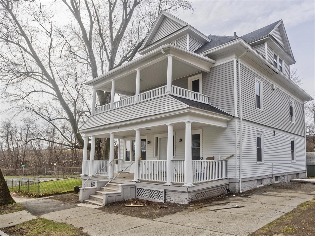 a view of a white house with large windows and a tree