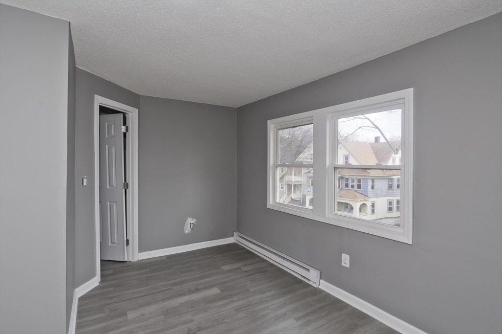 44 Eagle Street Springfield, MA 01107 - Photo 11 of 38 a view of an empty room with wooden floor and a window