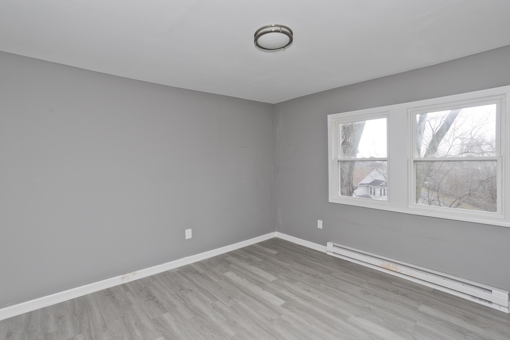 44 Eagle Street Springfield, MA 01107 - Photo 14 of 38 an empty room with wooden floor and windows