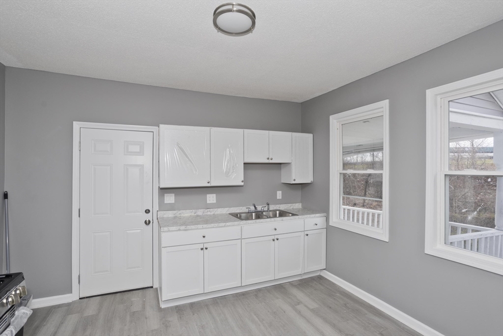 44 Eagle Street Springfield, MA 01107 - Photo 23 of 38 a view of a kitchen with white cabinets and wooden floor