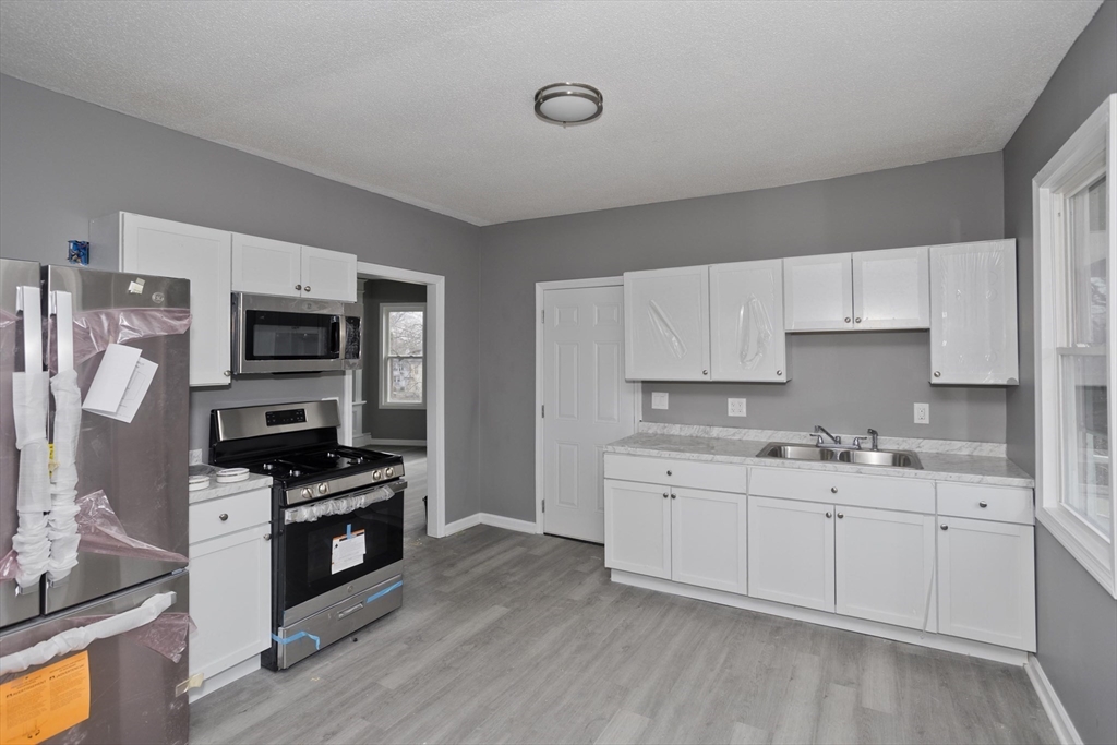 44 Eagle Street Springfield, MA 01107 - Photo 24 of 38 a kitchen with stainless steel appliances a sink stove and refrigerator