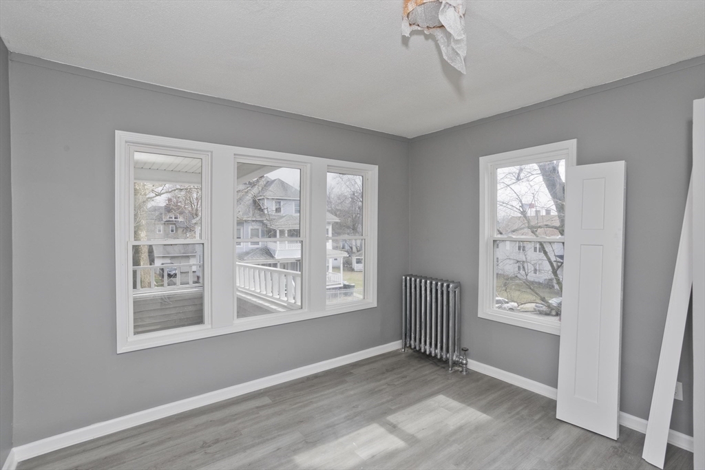 44 Eagle Street Springfield, MA 01107 - Photo 25 of 38 a view of an empty room with a window and wooden floor