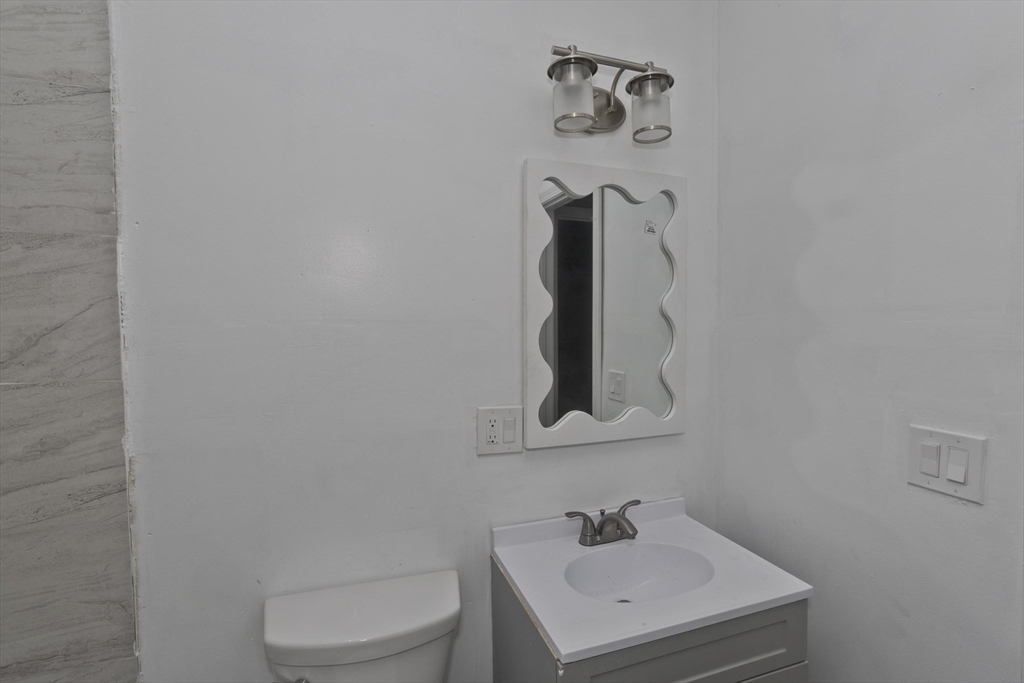44 Eagle Street Springfield, MA 01107 - Photo 30 of 38 a bathroom with a sink a toilet and mirror