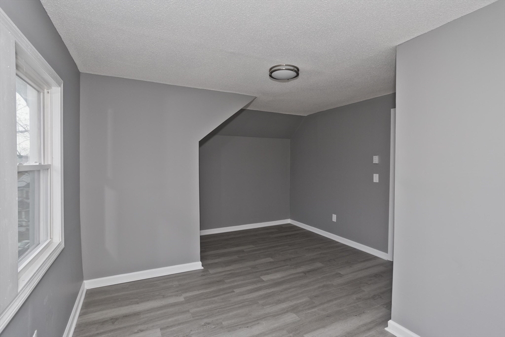 44 Eagle Street Springfield, MA 01107 - Photo 10 of 38 an empty room with wooden floor and windows