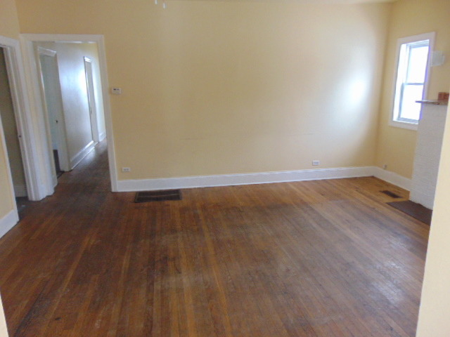 1 East 114th Street Chicago, IL 60628 - Photo 2 of 12 a view of an empty room with wooden floor and a mirror
