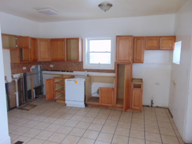 1 East 114th Street Chicago, IL 60628 - Photo 4 of 12 a kitchen with a stove a refrigerator and cabinets
