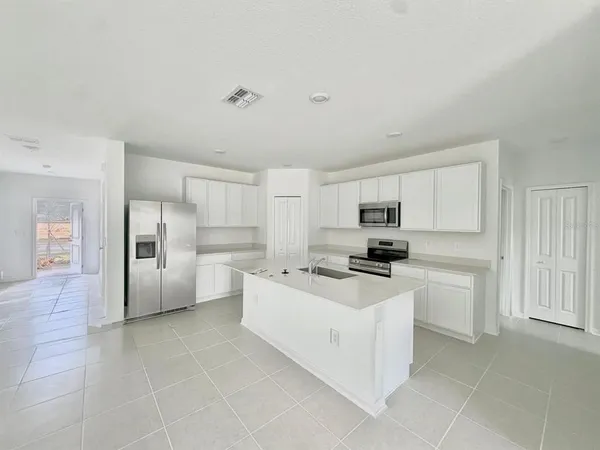 a kitchen with stainless steel appliances a refrigerator sink and cabinets