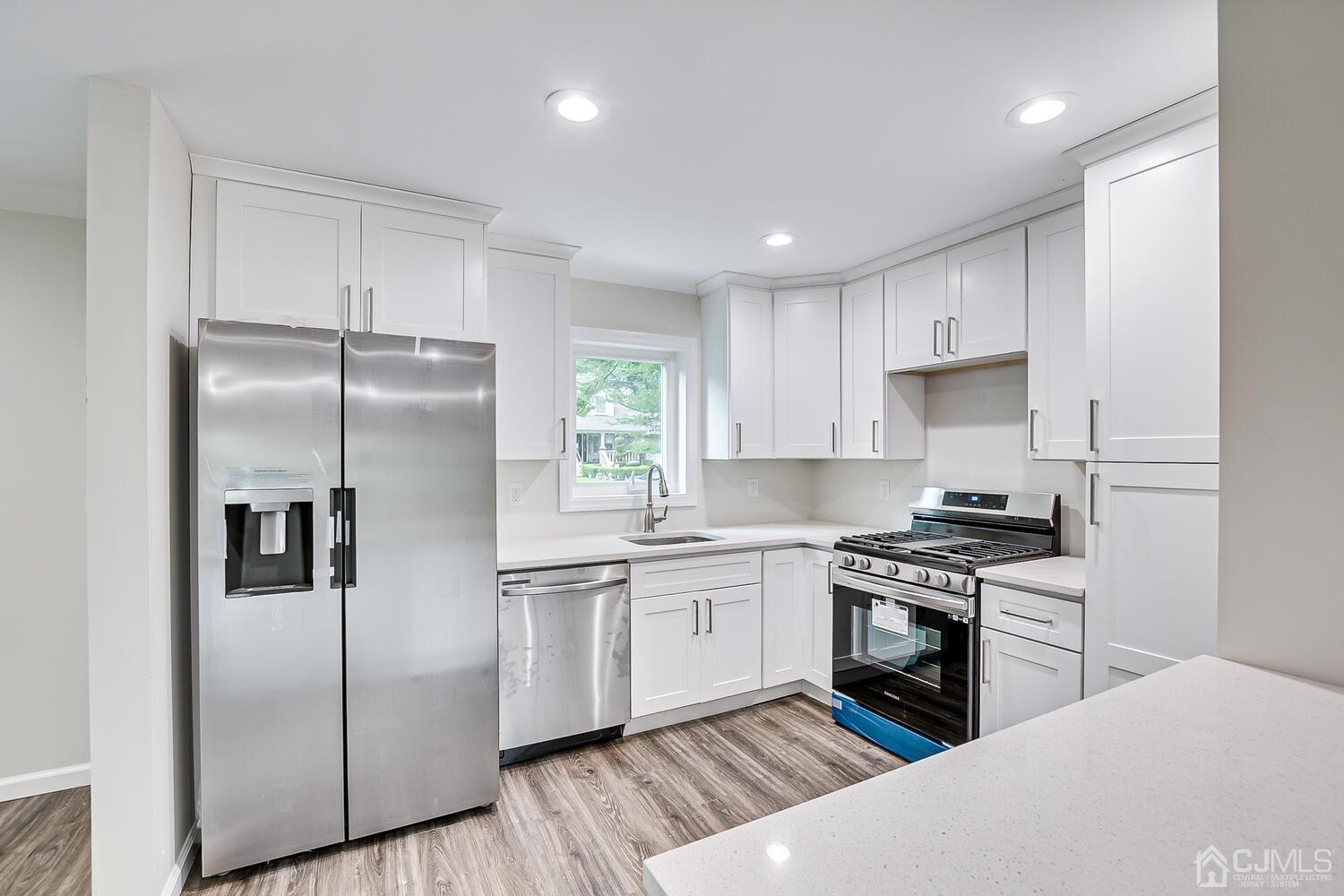 47 West Hill Road Colonia, NJ 07067 - Photo 4 of 18 a kitchen with stainless steel appliances granite countertop a stove a refrigerator and a sink with wooden floor