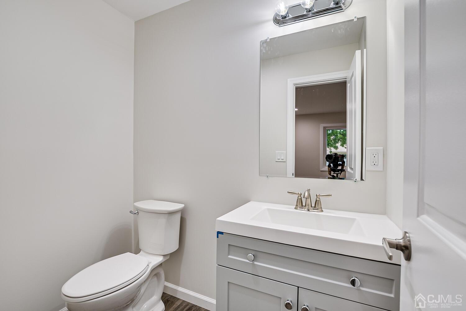 47 West Hill Road Colonia, NJ 07067 - Photo 9 of 18 a bathroom with a sink mirror and a toilet