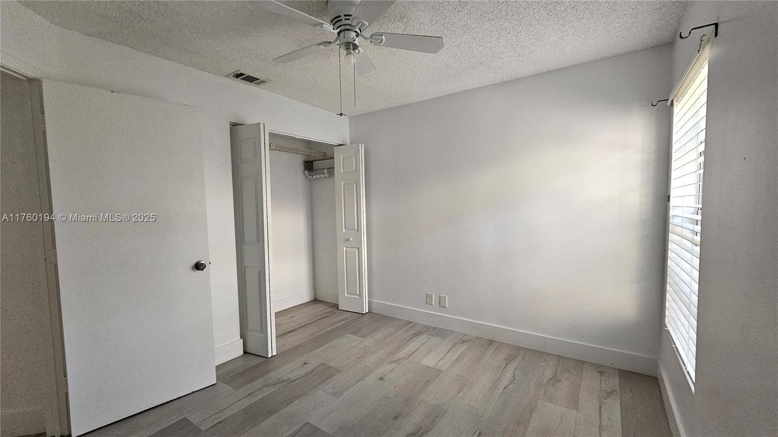 1350 Seagrape Circle Weston, FL 33326 - Photo 12 of 22 wooden floor in an empty room with a window