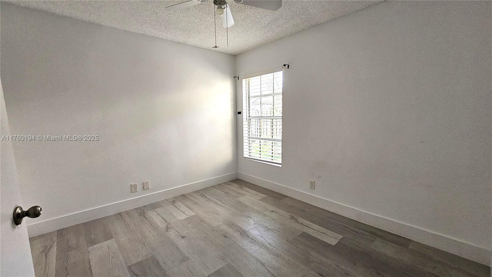 1350 Seagrape Circle Weston, FL 33326 - Photo 13 of 22 wooden floor in an empty room with a window
