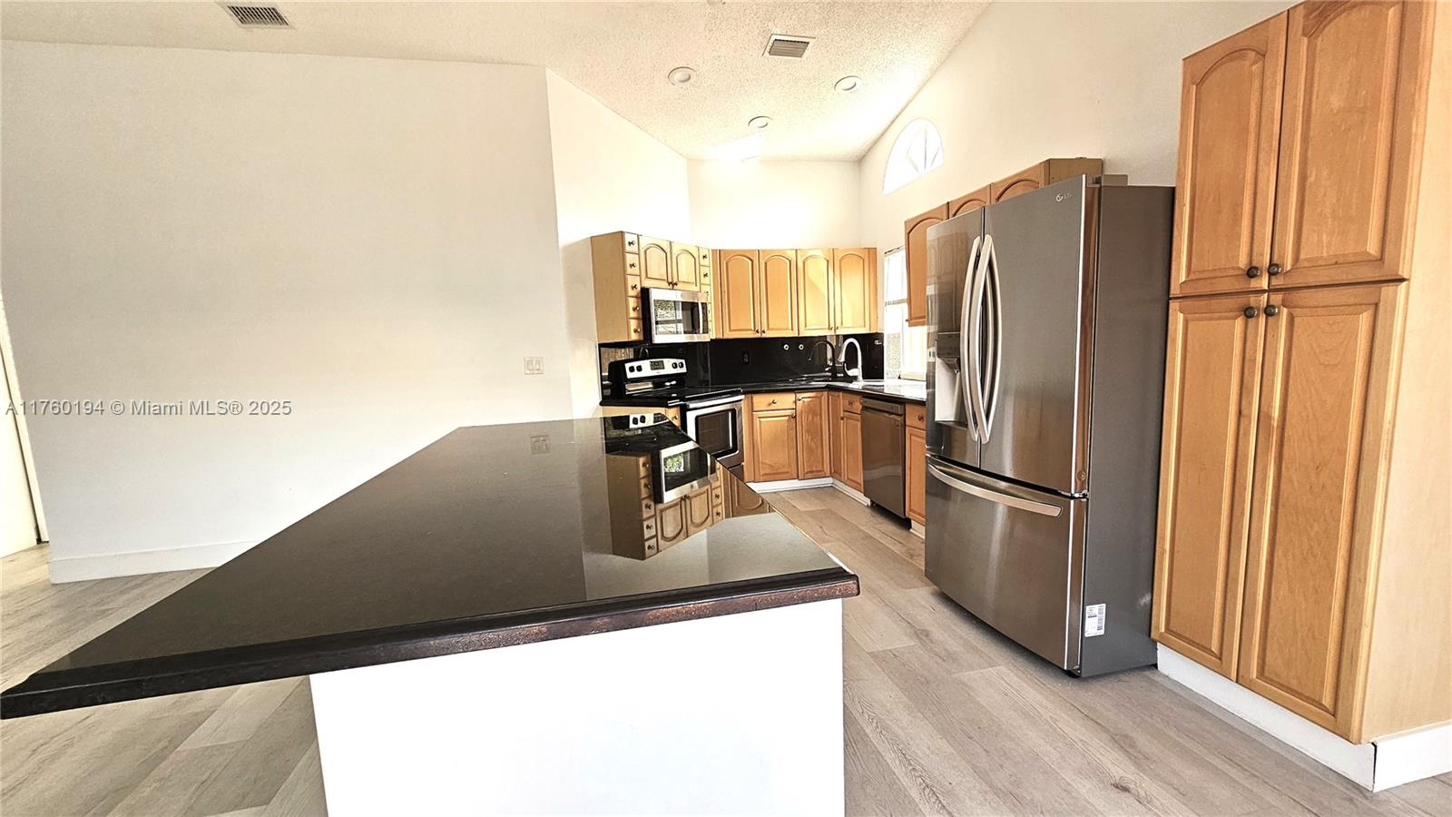 1350 Seagrape Circle Weston, FL 33326 - Photo 3 of 22 a kitchen with refrigerator and window