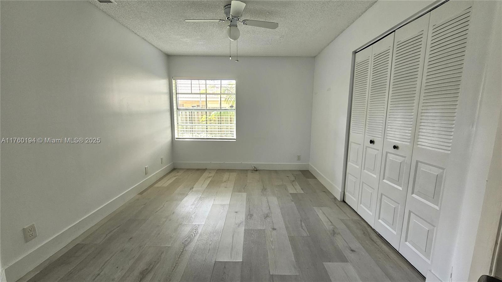 1350 Seagrape Circle Weston, FL 33326 - Photo 9 of 22 wooden floor in an empty room with a window