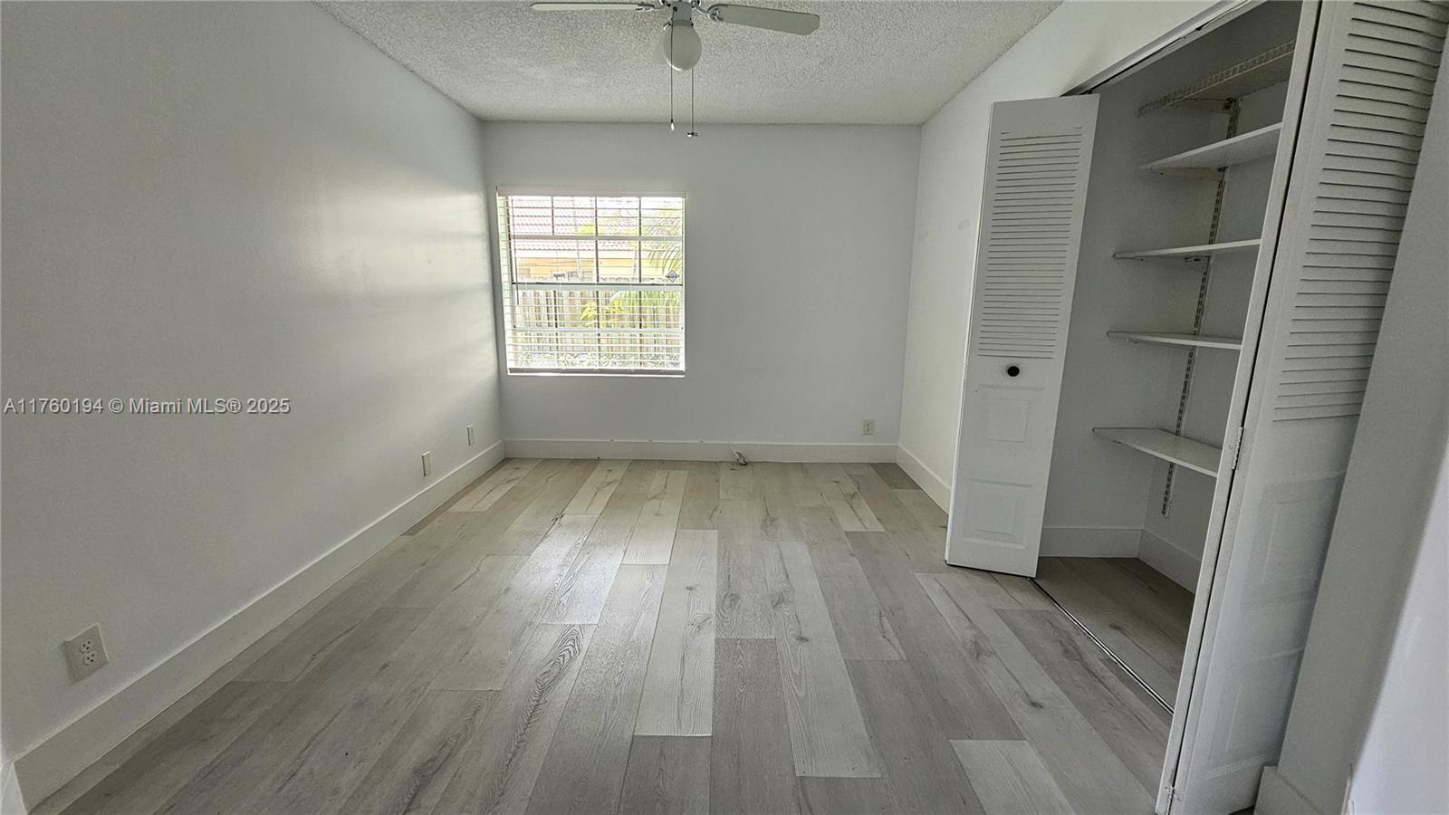 1350 Seagrape Circle Weston, FL 33326 - Photo 10 of 22 wooden floor in an empty room with a window