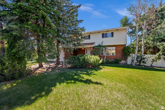 1650 Nichole Circle Sandy, UT 84093 - Photo 29 of 31 Two-story residence featuring a brick and siding exterior, front lawn, and mature trees
