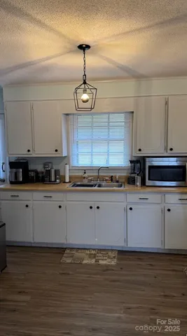 a kitchen with stainless steel appliances granite countertop a refrigerator a stove and a sink