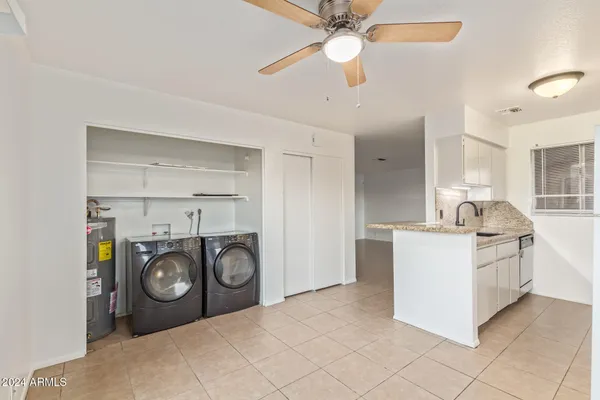 a white kitchen with a stove top oven and cabinets