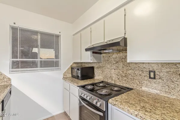 a kitchen with granite countertop a stove and a sink