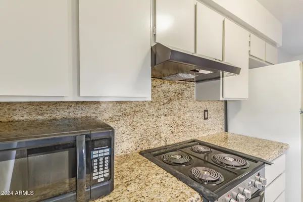 a stove top oven sitting inside of a kitchen