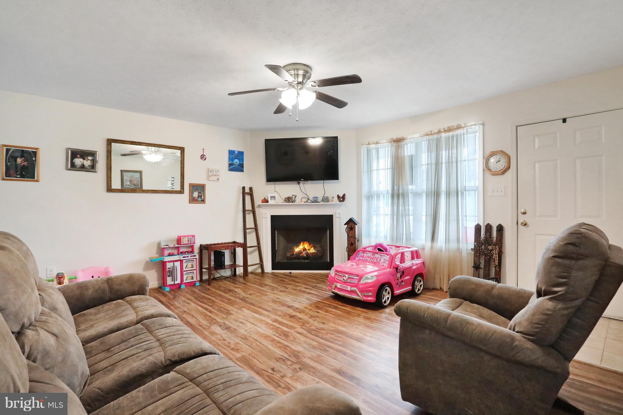 140 Raft Court Inwood, WV 25428 - Photo 5 of 34 a living room with furniture a flat screen tv and a fireplace