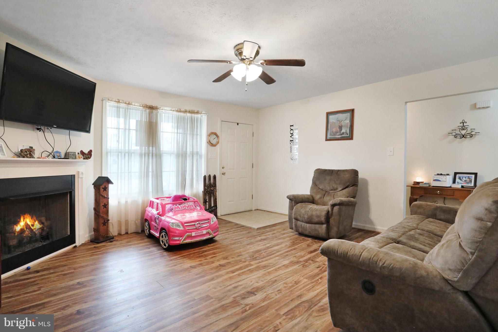 140 Raft Court Inwood, WV 25428 - Photo 6 of 34 a living room with furniture a flat screen tv and a fireplace