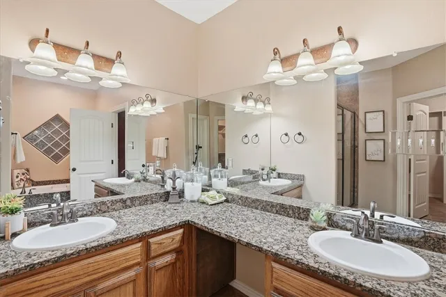 a bathroom with a granite countertop double vanity sinks and a mirror