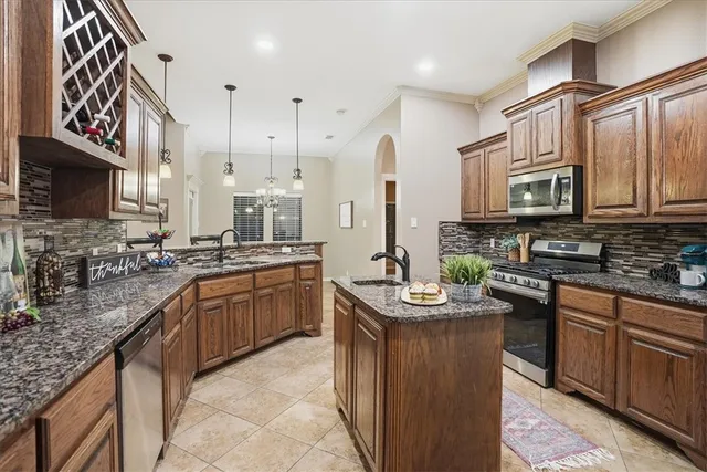 a kitchen with stainless steel appliances granite countertop a sink stove and cabinets