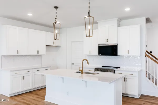 a kitchen with stainless steel appliances granite countertop a sink a stove and a refrigerator