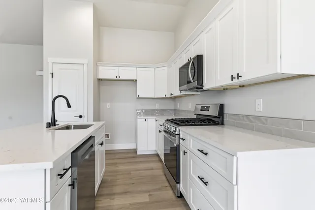 a kitchen with stainless steel appliances granite countertop a sink stove and cabinets