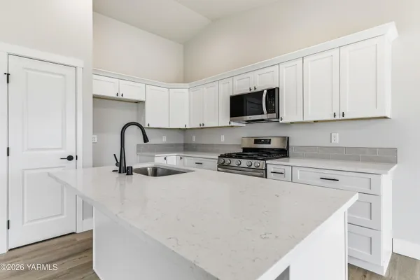 a kitchen with stainless steel appliances granite countertop a sink a stove and a refrigerator