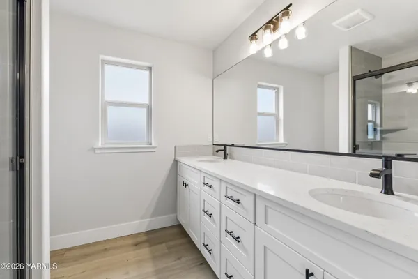 a bathroom with double vanity sink and a mirror