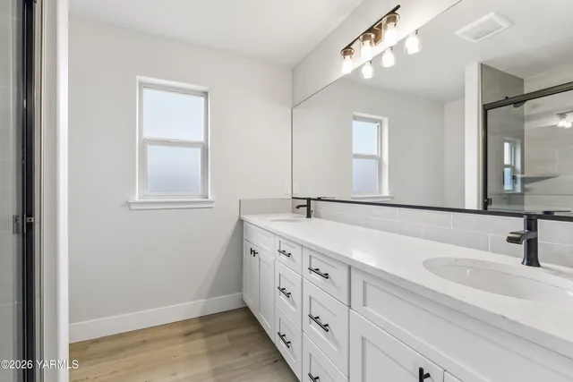a bathroom with double vanity sink and a mirror